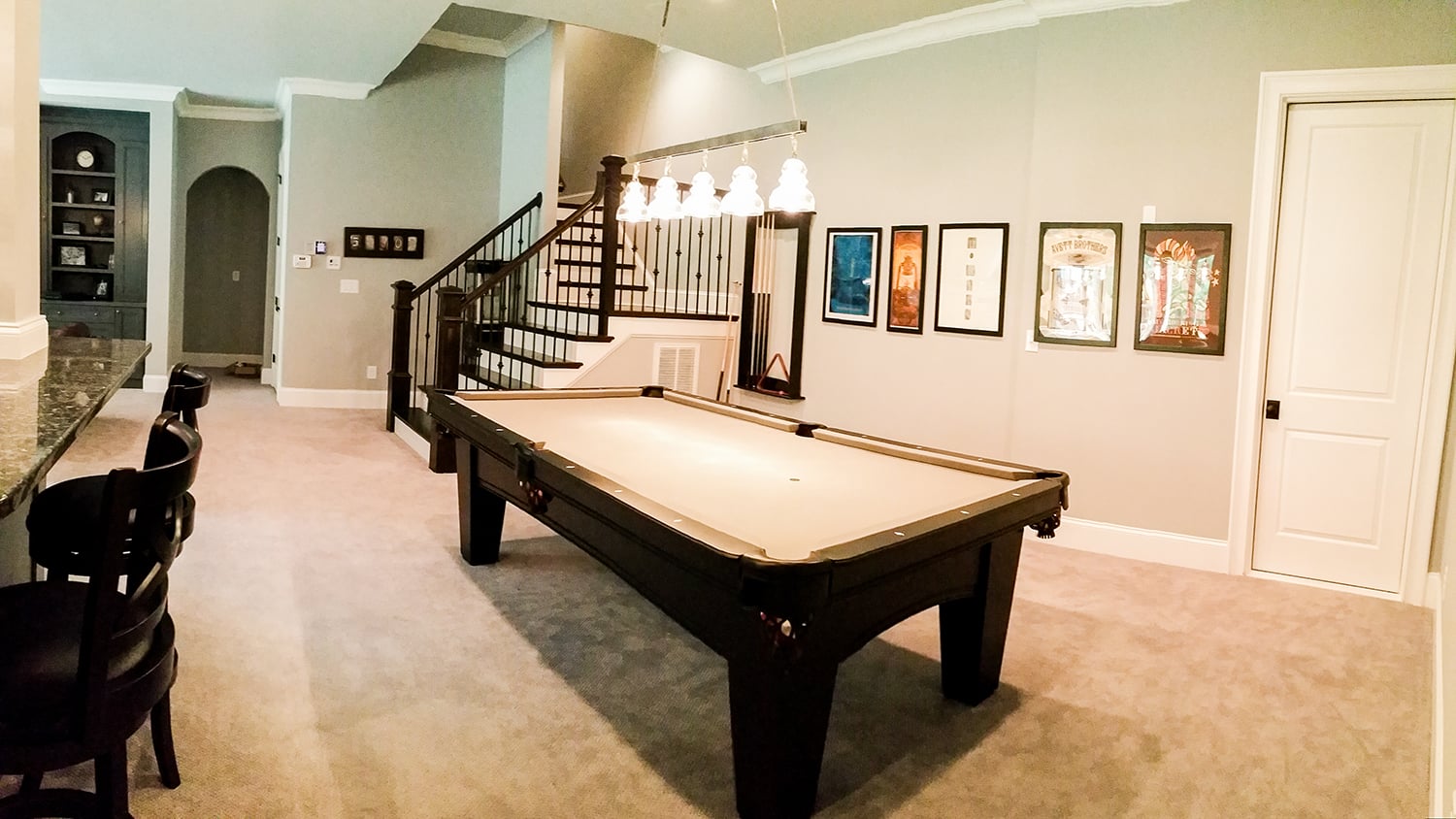 Remodeled basement with custom billiards area and lounge seating