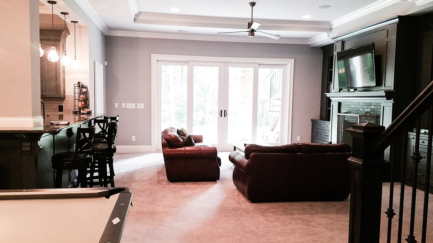 Custom bar and shelving with recessed lighting in the finished basement