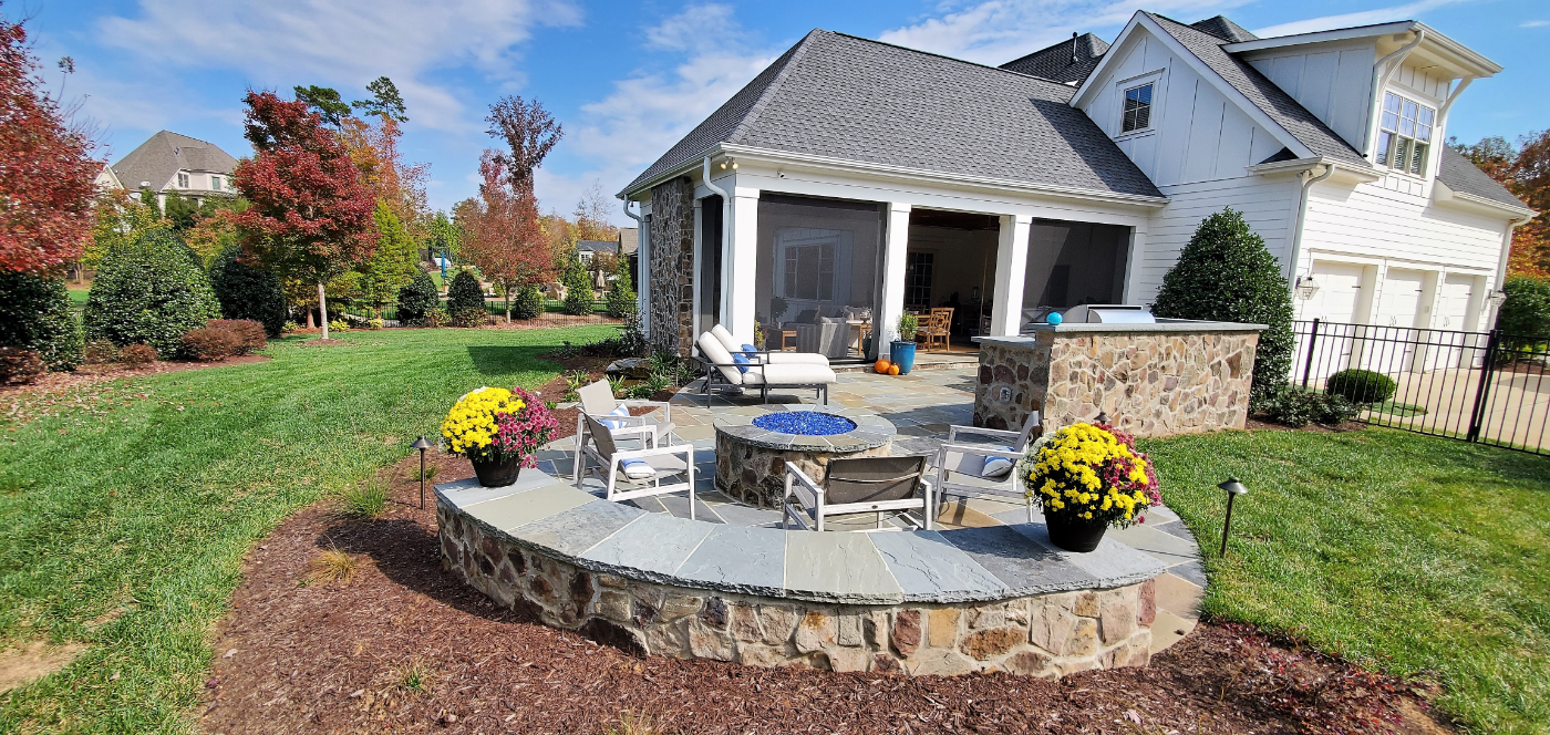 Gas firepit with glass rocks set into a stone seating wall on the open patio