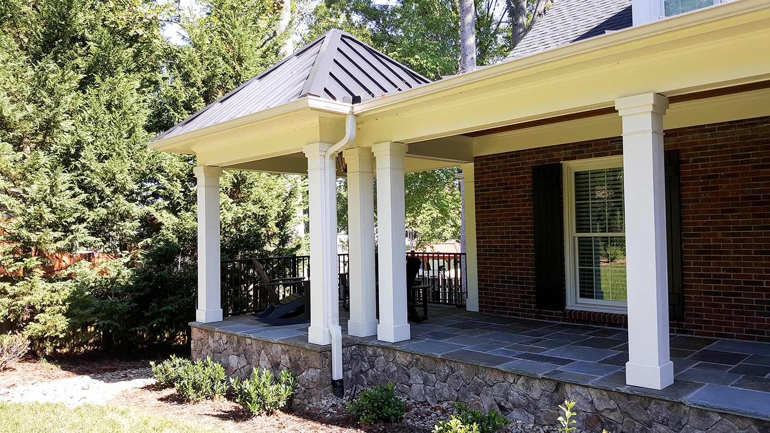 Stone foundation, composite trim, and black handrails at the front porch