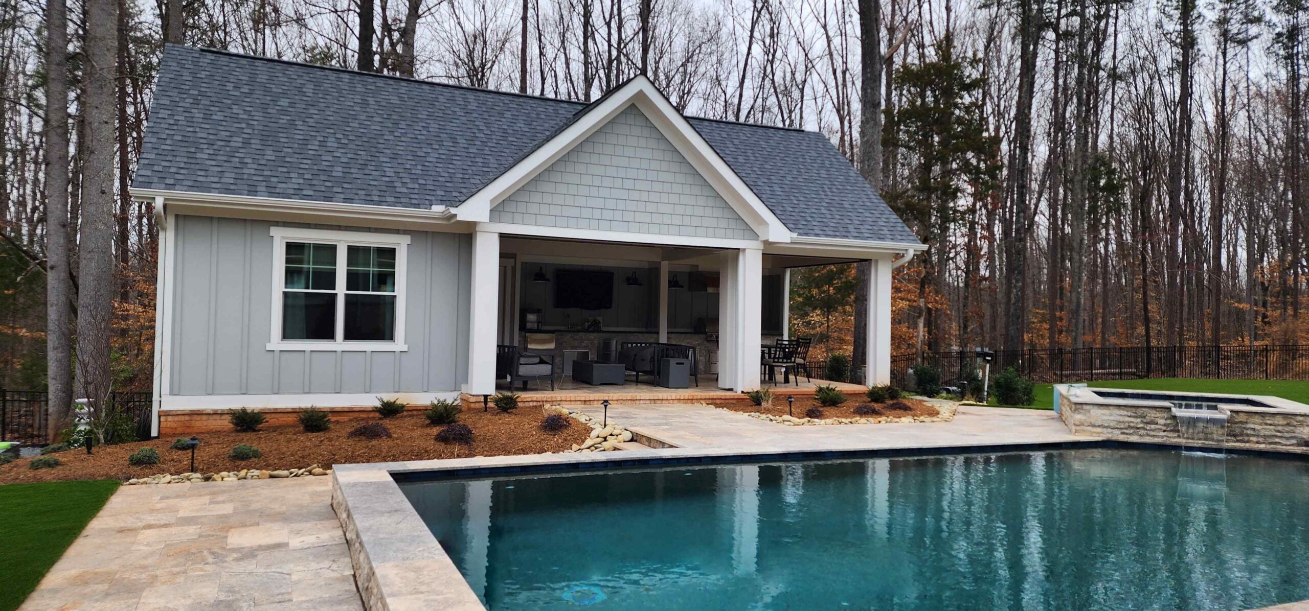 Pool house in Davidson, NC with a guest bedroom and bathroom alongside a covered porch and grilling area